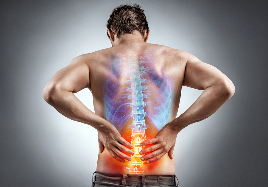 Man holding lower back with glowing spine illustration showing pain in lumbar region