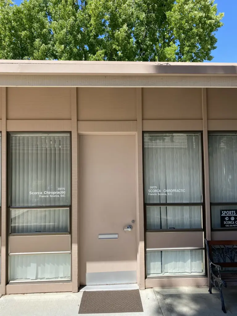 The office door, with "39775 Scorca Chiropractic, Francis Scorca, D.C." lettered on the window beside it