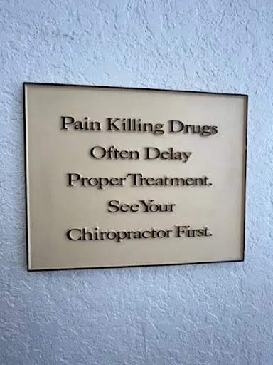 A sign on the office wall: "Pain killing drugs often delay proper treatment. See your chiropractor first."